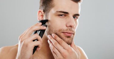 homme qui se rase les poils du nez et des oreilles avec une tondeuse