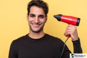 homme qui tient un sèche-cheveux cheveux pour se coiffer lui meme