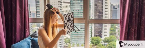 femme qui utilise une brosse lissante pour coiffer et sécher ses cheveux