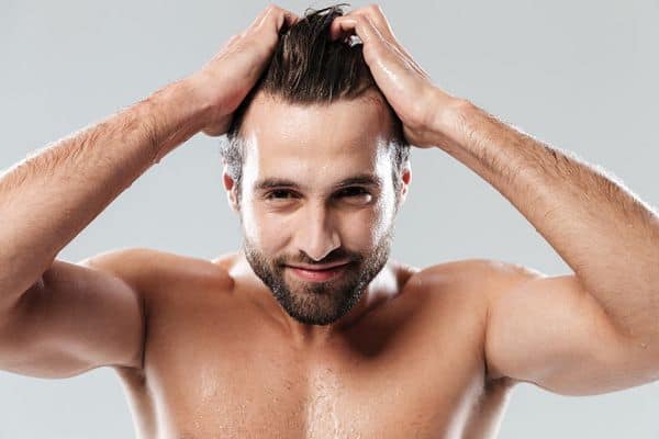 homme qui s'est coiffé sous la douche avec un shampoing bio