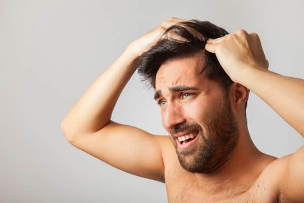 homme qui cherche une solution à son début de calvitie et sa chute de cheveux